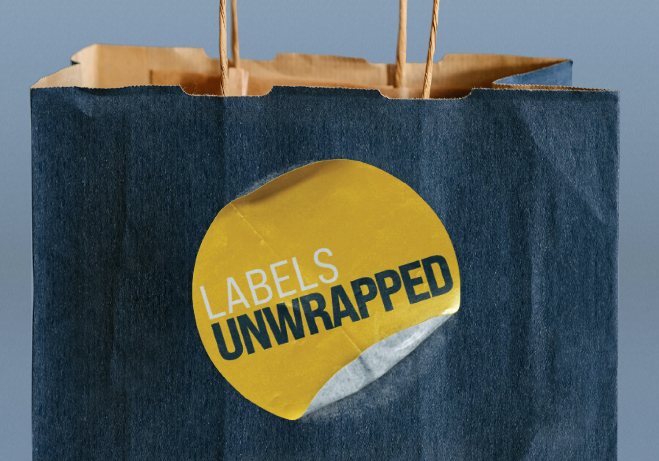 A paper bag with a sticker that says "Labels Unwrapped"