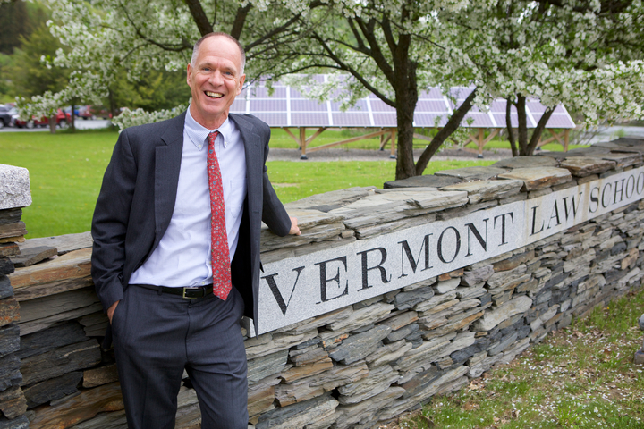 Dean Tom McHenry stands by the Vermont Law School sign in front of Waterman Hall
