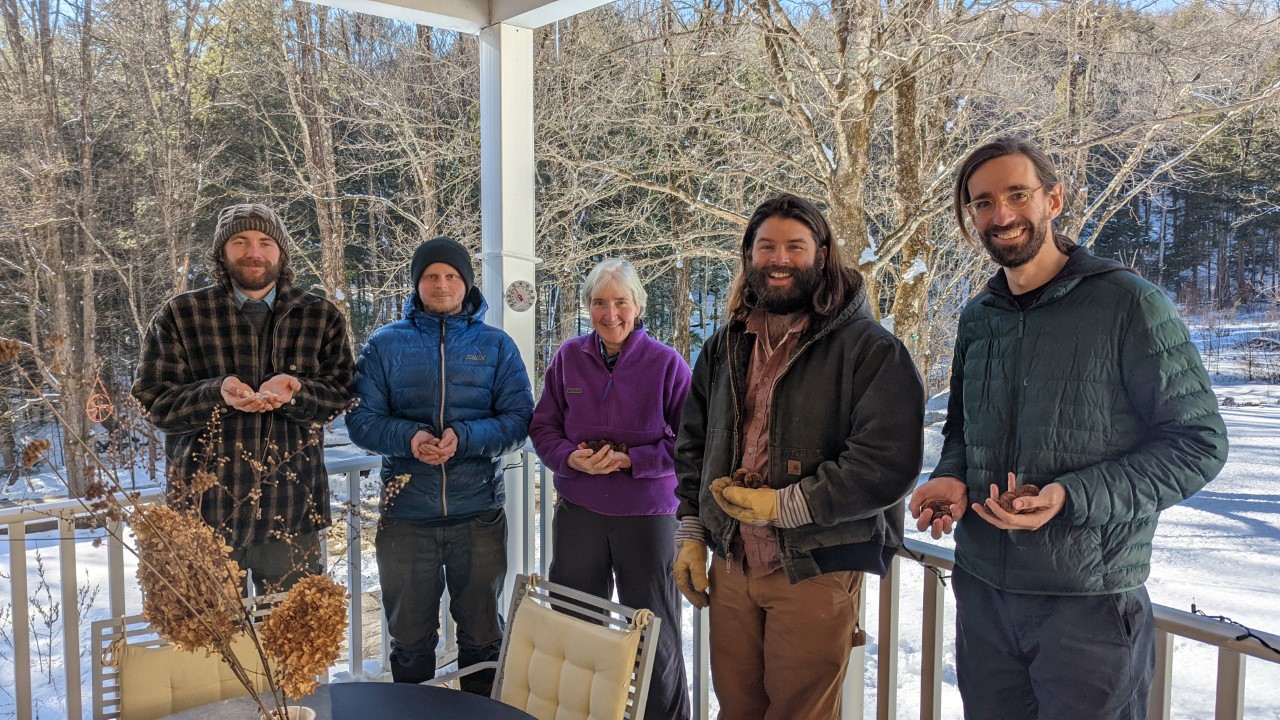 A group of people standing outside holding native Vermont Nuts
