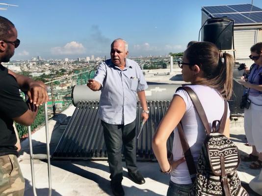 Professor Conrado Moreno talks renewable energy on a Havana rooftop