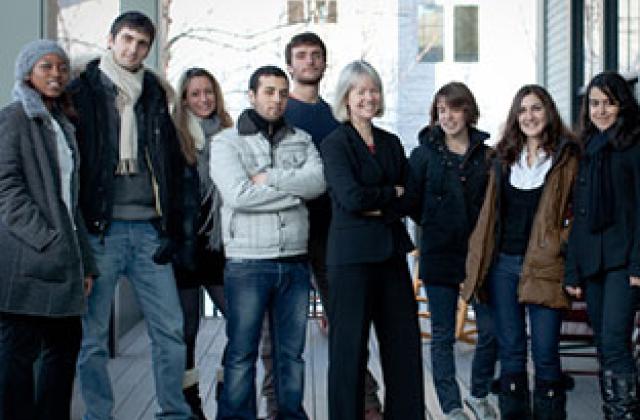 Professor Stephanie Farrior poses on the back porch of Debevoise Hall with a group of international students
