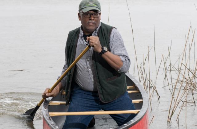 Fred Tutman paddles a canoe.