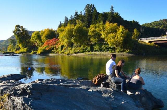 Students sit by the White River on VLS campus.