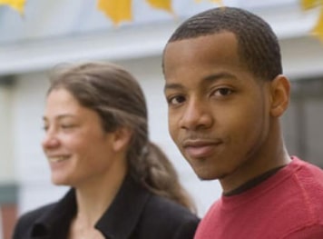 Two young students smiling towards the camera.