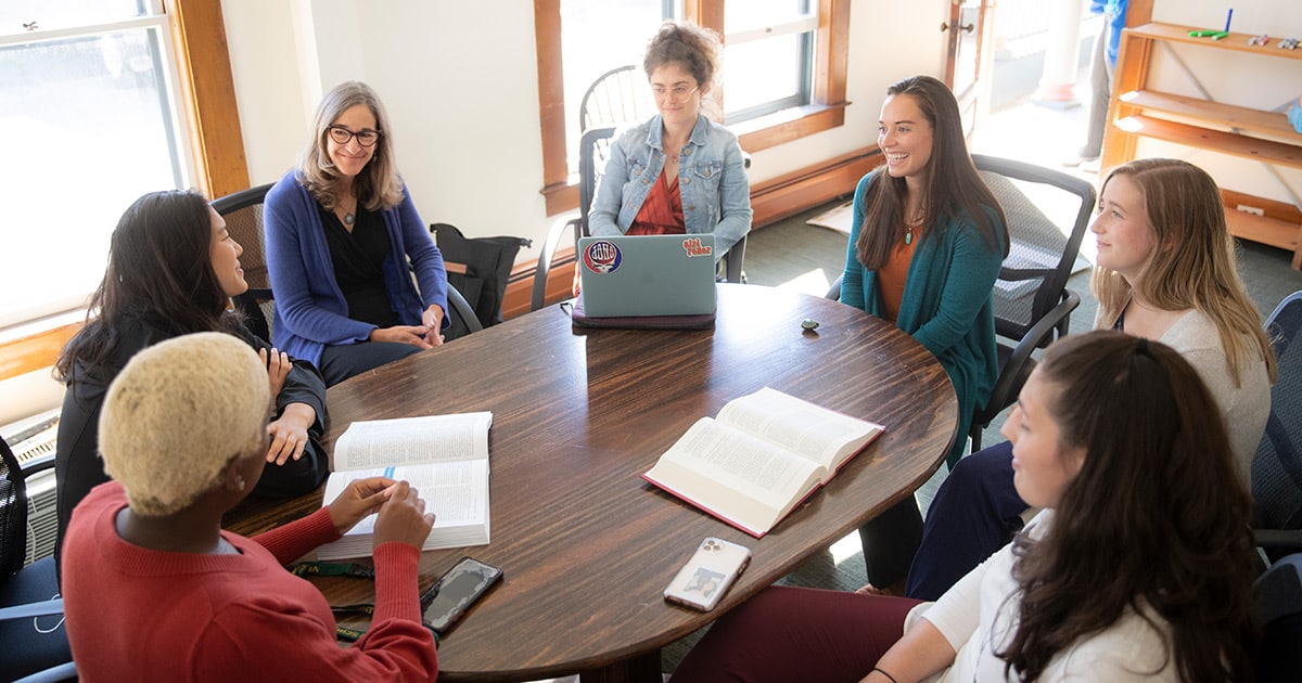 A group of VLGS students and faculty members sitting in a circle for a class discussion.