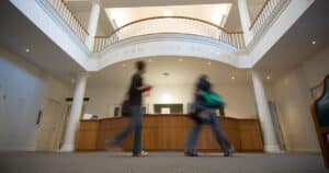 Two students walking through the library.