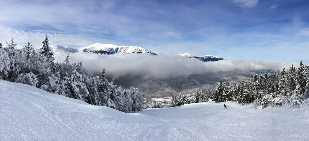 A snowy landscape of mountains and trees.