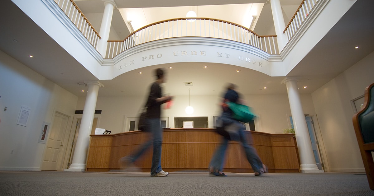 Two students walking through the library
